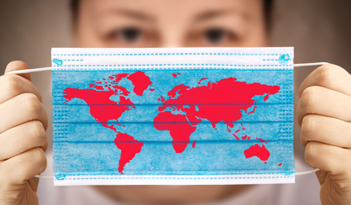 Face,Mask,In,Hand,With,World,Map.,Covid-19,Outbreak,Around